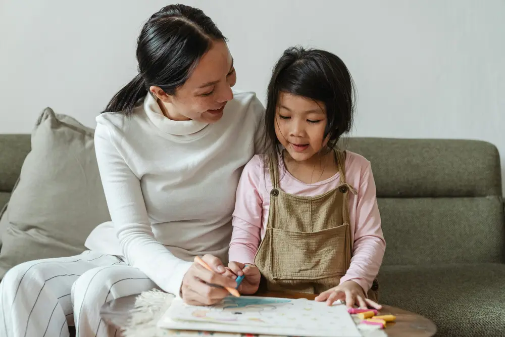 A mother and daughter drawing together at home